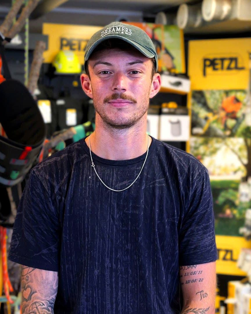 Michel Skogqvist i Arboristbutikens butik foran klatreseler og Petzl-udstyr.